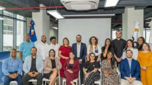 Fotografía grupal de participantes y autoridades durante un taller institucional en una sala de reuniones.